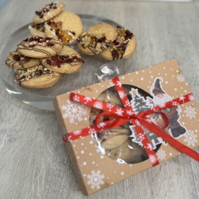 Shortbread cookies served on a cake board with some served and wrapped in a box to be gifted